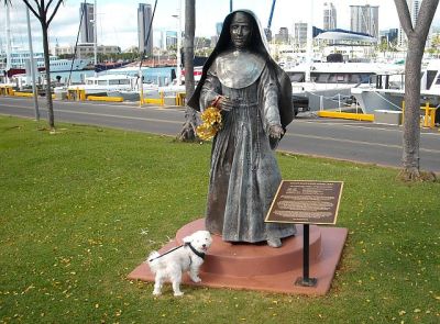 Our favorite Fluff Pup visits the statue of Marianne Cope. Btw, the giant yacht in the upper left corner is Larry Ellison's "Musashi".